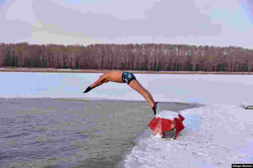A winter swimmer dives into the icy water of the Songhua River in Songyuan, Jilin Province, China. (Reuters/Stringer)
