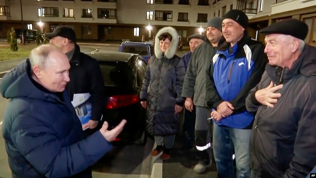 Vladimir Putin discută cu câțiva oameni, prezentați ca localnici din Mariupol, într-o înregistrare difuzată de Russian TV Pool duminică, 19 martie 2023.