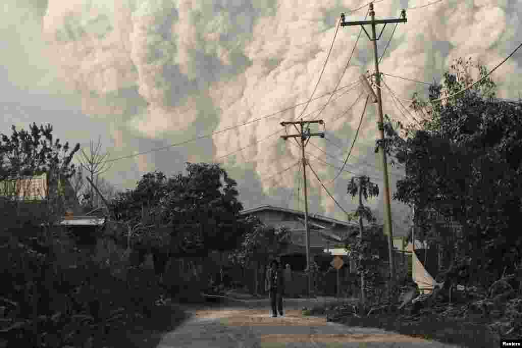 A villager walks as Mount Sinabung erupts at Beras Tepu village in Karo district, Indonesia's North Sumatra Province. (Reuters/Beawiharta)