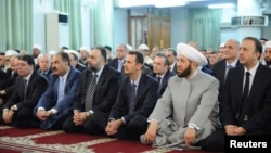 Президент Сирии Башар Асад (третий справа в первом ряду) на молитве в мечети в честь праздника Ид аль-Фитр. Дамаск, 8 августа 2013 года.