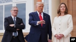 President Donald Trump, center, speaks with the media as he greets Britain's Prime Minister Keir Starmer, left, and his wife Victoria in Turnberry, Scotland.