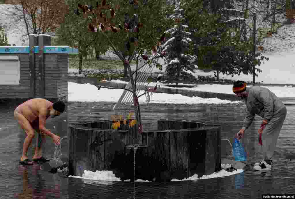 Residents are seen near a city well during the first snowfall, amid Russia&#39;s attack on Ukraine, in Kharkiv, Ukraine, on November 14.