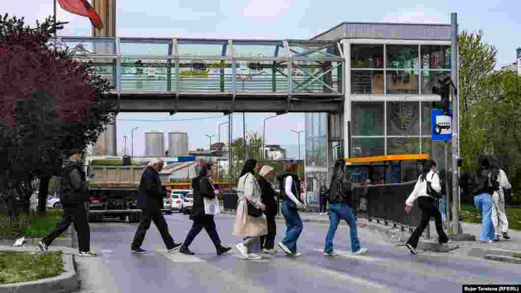 Njerëzit kalojnë rrugën në zebra pranë një mbikalimi tashmë të pashfrytëzuar në një nga lagjet më të frekuentuara të kryeqytetit, lagjja e "Spitalit".