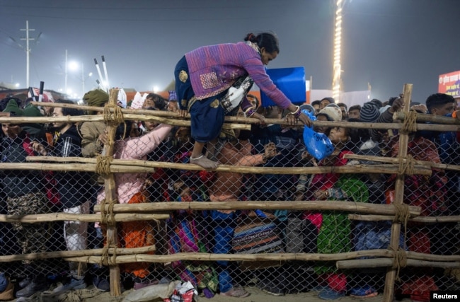 Një besimtare kalon një gardh gjatë festivalit fetar në Indi. 29 janar 2025