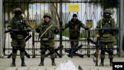 Bărbați înarmați păzesc o unitate militară ucraineană din satul Perevalnoie, lîngă Simferopol,19 martie 2014
