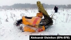 Human remains and plane debris are scattered across a large area of the crash site.