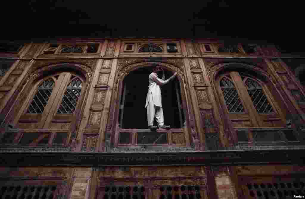 A man cleans the windows of a historical building built in the 19th century in Peshawar, Pakistan, on November 4. (Reuters/Fayaz Aziz)