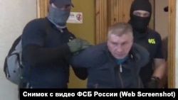 FSB officers arrest Russian serviceman Dmitry Dolgopolov (center) on suspicion of spying for Ukraine.