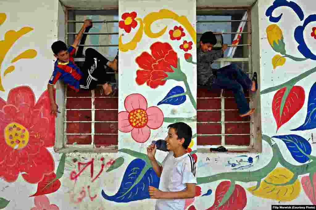 "The Castle" was opened to refugees in 2013. These children are playing on the bars of the former prison cell windows.