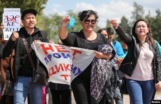 "Диктатураның билеп-төстеуіне жол жоқ!" деген жазу ұстаған адамдар. Алматы, 1 мамыр 2019 жыл.