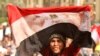 An antigovernment protester waves a bloodstained Egyptian flag in Cairo's Tahrir Square on February 4.