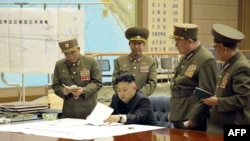 North Korean leader Kim Jong Un (seated) is seen in an official handout photo reportedly discussing a strike plan with North Korean officers during an urgent operation meeting at the Supreme Command in an undisclosed location.