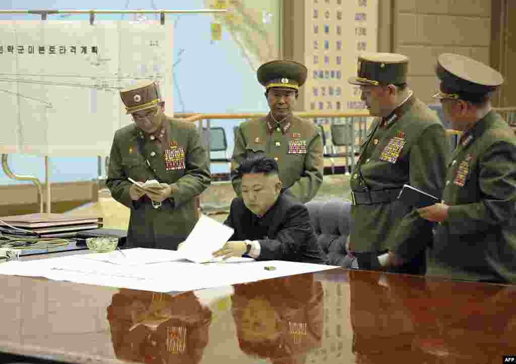 Ким Чен Ын обсуждает с военными пран удара на экстренной встрече верховного командования 29 марта 2013 г. Место действия не раскрывается. На заднем фоне - схема перемещения 7 флота США в Тихом океане. 