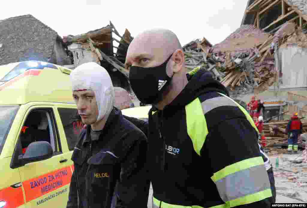 Muškarac spovredom glave otpraćen je od zgrada oštećenih u zemljotresu u Petrinji u Hrvatskoj, 29. decembra 2020. EPA-EFE / ANTONIO BAT
