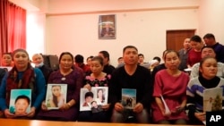 Relatives of those missing in China's western region of Xinjiang hold photos at an office of a Chinese Kazakh advocacy organization in Almaty, Kazakhstan, on December 7, 2018.