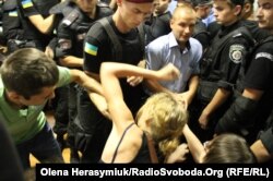 Працівники спецпідрозділу «Грифон» виводять з зали суду дівчину за порушення порядку