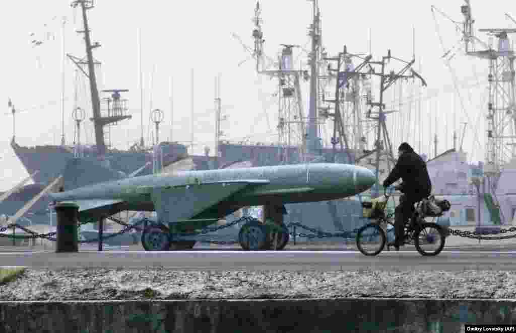 A man rides a bike past a Soviet-era rocket at a navy base in Kronstadt, a seaport town 30 kilometers west of St. Petersburg. (AP/Dmitri Lovetsky)