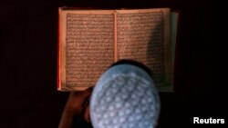Молодой мусульманин за чтением Корана. Иллюстративное фото. 