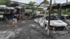 A resident stands next to burned cars at the site of a Russian drone strike on the Ukrainian city of Dnipro on July 26. 