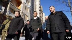 U.K. Prime Minister Rishi Sunak (center) is escorted during a tour of damaged buildings in Kyiv upon his arrival to Ukraine on January 12.