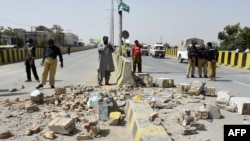 Pakistani security officials inspect the site of a roadside bomb blast in Quetta on August 11.