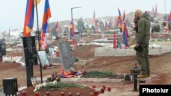 Armenia - A man prays at one of the fresh graves of Armenian soldiers killed in the 2020 war in Nagorno-Karabakh and buried in the Yerablur military pantheon in Yerevan, January 28, 2021.