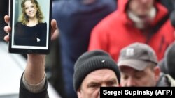 A man holds a tablet showing photograph of Iryna Nozdrovska during a rally outside the Kyiv police headquarters on January 2.