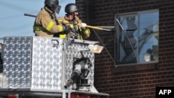 Паліцыя ламае вакно ў кватэры Джэймса Холмса