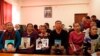 Relatives of those missing in China's western region of Xinjiang hold photos at an office of a Chinese Kazakh advocacy organization in Almaty, Kazakhstan, on December 7, 2018.