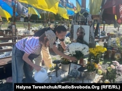 Дружина і донька біля могили чоловіка і батька Олега Хомицького