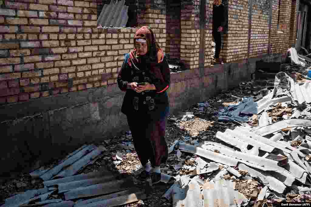 A Kyrgyz woman stands in front of her destroyed house in the village of Maksat on May 2. Kyrgyz Deputy Health Minister Aliza Soltonbekova said a total of 36 Kyrgyz citizens died, 189 people were injured, and 58,000 were evacuated during violence that erupted on April 28 and lasted for almost three days, Kyrgyz officials say, over a Tajik move to install surveillance cameras on a disputed part of the border. (AFP/Danil Usmanov)