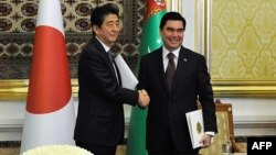 Turkmen President Gurbanguly Berdymukhamedov (right) shakes hands with Japanese Prime Minister Shinzo Abe following their meeting in Ashgabat on October 23. 