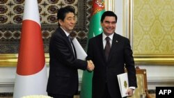 Turkmen President Gurbanguly Berdymukhamedov, right, shakes hands with Japanese Prime Minister Shinzo Abe during a signing ceremony following their meeting in Ashgabat on October 23.