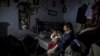 A man plays with his son as he sits in his one-room home in a Christian slum in Islamabad, Pakistan. (Reuters/Zohra Bensemra)