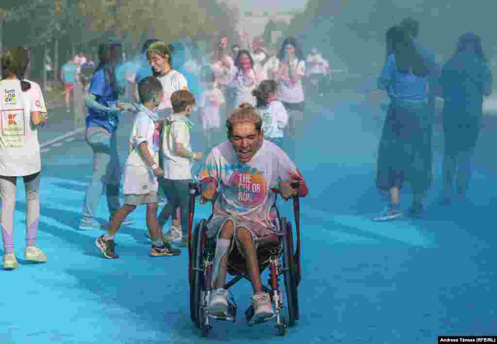 Un bărbat în scaun cu rotile participă la cursa &bdquo;The Color Run&rdquo;, în București. The Color Run este o cursă necronometrată de 5 kilometri, în cadrul căreia mii de participanți sunt vopsiți din cap până în picioare în diverse culori, la finalul fiecarui kilometru parcurs.&nbsp;