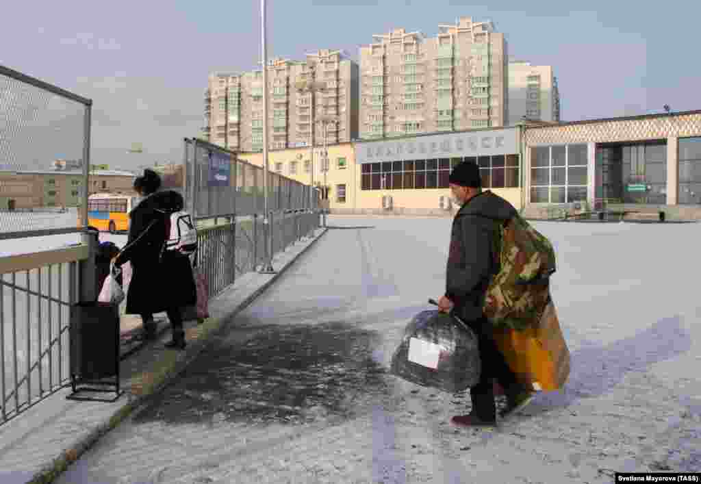Chinese citizens pass through a border checkpoint between Blagoveshchensk, Russia, and Heihe, China. Temporary crossings were opened briefly after the Russian government ordered its borders with China to be closed as a measure to prevent the spread of the coronavirus. Each person passing through the temporary corridor was tested for the virus.