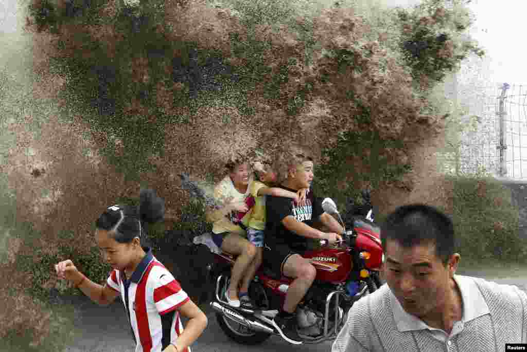 Visitors flee as waves caused by a tidal bore surge past a barrier on the banks of Qiantang River, in Hangzhou, in China&#39;s Zhejiang Province. (Reuters)