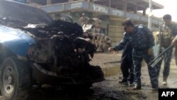 Iraqi security forces inspect the damage at the site of the bombing in Ramadi.