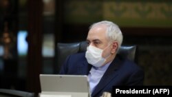 Iranian Foreign Minister Mohmmad Javad Zarif wears a protective mask and gloves as protection against the cornonavirus COVID-19, during a cabinet meeting in the capital Tehran, March 11, 2020