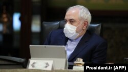 Iranian Foreign Minister Mohmmad Javad Zarif wears a protective mask and gloves as means of protection against the cornonavirus COVID-19, during a cabinet meeting in the capital Tehran, March 11, 202