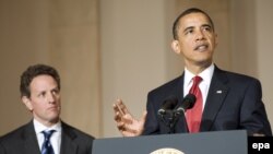 U.S. President Barack Obama (right) speaks about tax reform as Treasury Secretary Timothy Geithner looks on at the White House.