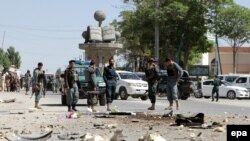 FILE: Afghan policemen inspect the scene of a bomb blast in Ghazni in June 2016.