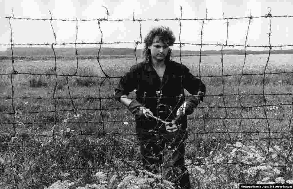 A worker cuts the fence between Hungary and Austria.&nbsp; In May 1989, a 240-kilometer-long fence along Hungary&rsquo;s border with Austria was deemed more trouble than it was worth. The expensive barrier was equipped with sensors designed to detect people fleeing into the West but by 1989 the fence was increasingly problematic.&nbsp;Automated alarm rockets were being triggered by wild animals, or nothing at all. &nbsp;