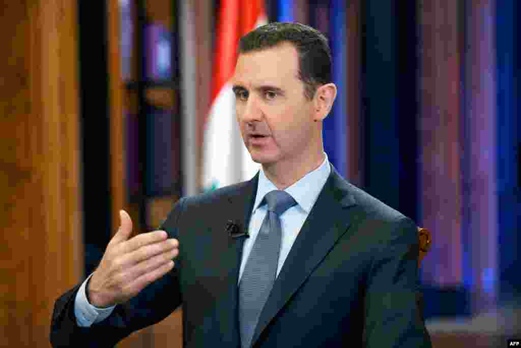 18 сентября Совбез ООН не смог достичь компромисса для принятия резолюции по Сирии. Одобрение этого документа является одним из ключевых этапов внедрения плана США и России по уничтожению химического арсенала Дамаска в течение года. Президент Сирии Башар Асад тем временем заявил, что на уничтожение химоружия понадобится год и около миллиарда долларов США. В интервью Fox News 18 сентября Асад сказал, что &laquo;убедительные и очевидные доказательства&raquo; применения зарина, о которых говорится в докладе, представленном экспертами ООН, на самом деле &laquo;нереалистичны&raquo;. На фото: президент Сирии Башар Асад. Дамаск, 19 сентября 2013 года.