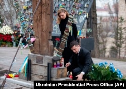 Ukrainian President Volodymyr Zelenskiy and his wife, Olena, pay their respects at the memorial dedicated to people who died in clashes with security forces in 2014 on Independence Square in Kyiv on February 20, 2020.