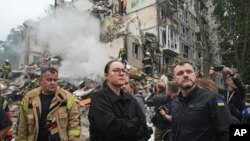 უკრაინის პრემიერ-მინისტრი იულია სვირიდენკო და შინაგან საქმეთა მინისტრი იჰორ კლიმენკო კიევში რუსული რაკეტით განადგურებულ სახლთან. 2025 წლის 31 ივლისი