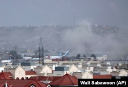 Smoke rises from the first explosion outside the airport in Kabul.