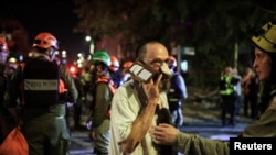 Pripadnik spasilačke ekipe pomaže muškarcu povrijeđenom u iranskom raketnom napadu, u Ramat Ganu, 13. juna