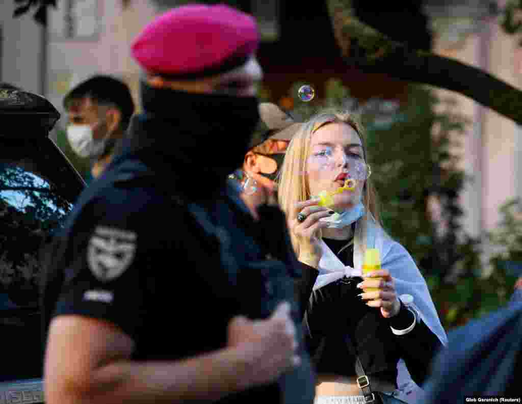 An activist blows bubbles as she attends a rally to support Belarus&#39;s anti-government movement, one year after the disputed reelection of strongman ruler Alyaksandr Lukashenka, next to the Belarusian Embassy in Kyiv on August 8.