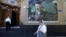 An Iranian woman walks past a mosque decorated with a banner depicting Iranian Supreme Leader Ayatollah Mojtaba Khamenei in Tehran on May 9. 